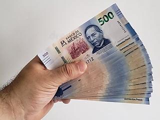 Repartidor sosteniendo billetes — cobertura de adeudo de DiDi Food con Xigoo